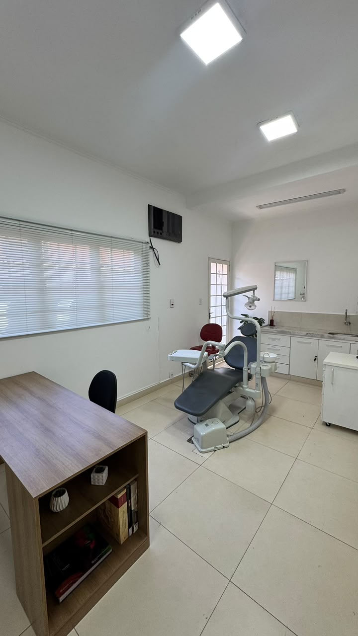 Consultório com cadeira odontológica, bancada e iluminação clínica